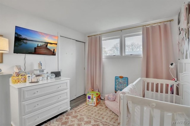 bedroom with a crib and wood finished floors