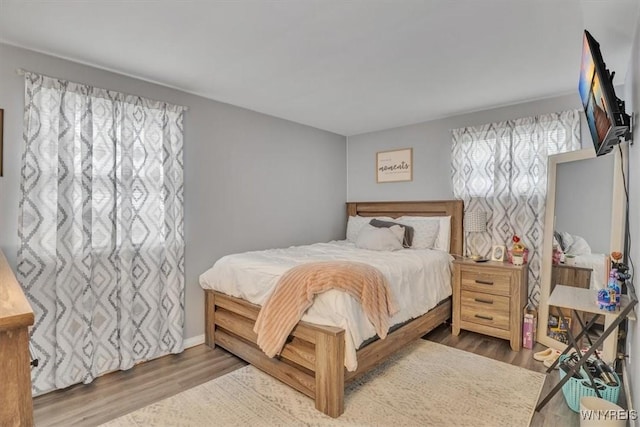 bedroom with baseboards and wood finished floors