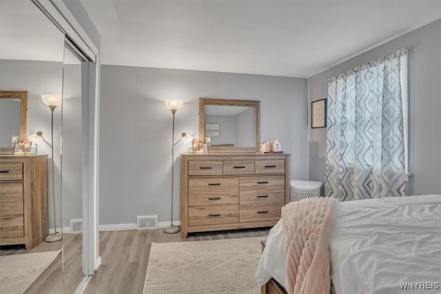 bedroom featuring baseboards, visible vents, and light wood-style flooring
