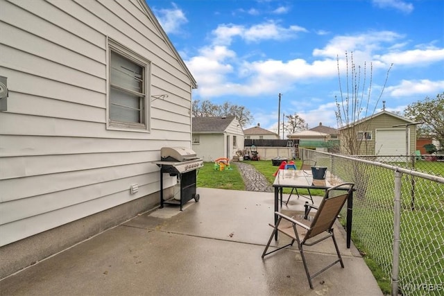 view of patio / terrace with grilling area, a fenced backyard, and a detached garage