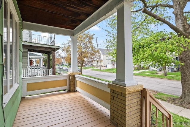 wooden deck featuring covered porch and a residential view