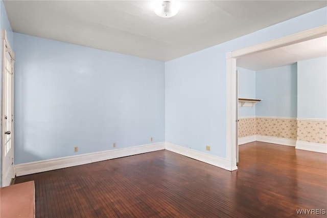 unfurnished room featuring baseboards and wood finished floors