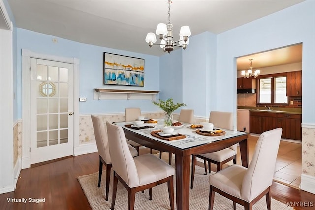 dining area featuring baseboards, dark wood finished floors, and a chandelier
