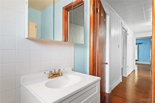 bathroom with vanity, decorative backsplash, and wood finished floors