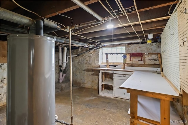 basement with water heater and a workshop area