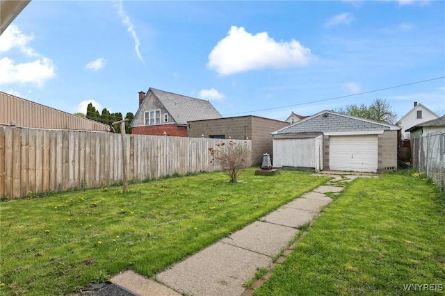 view of yard featuring a fenced backyard, an outdoor structure, and a garage