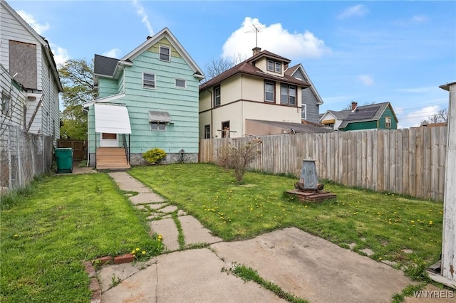 back of property featuring a fenced backyard and a yard