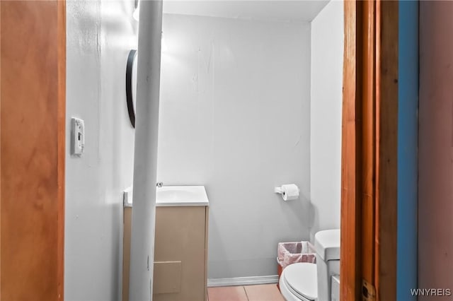 bathroom featuring vanity, tile patterned flooring, and toilet