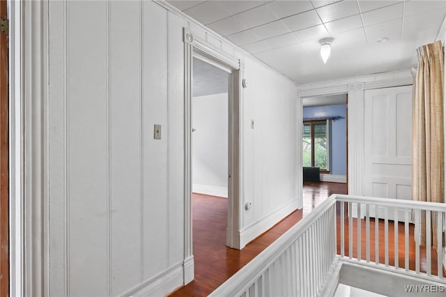 hall featuring baseboards and dark wood-style flooring