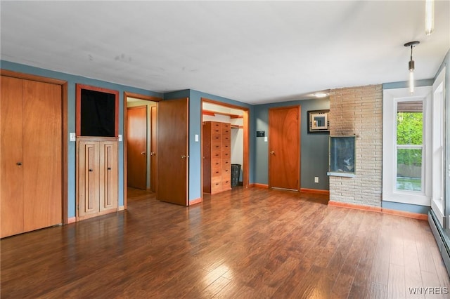 unfurnished living room with baseboards, wood finished floors, and baseboard heating