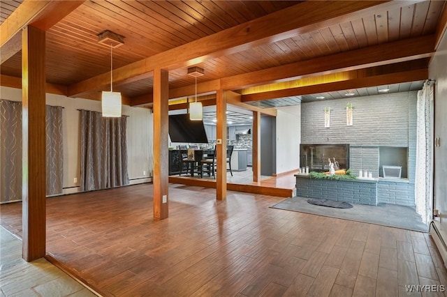 unfurnished living room with wood ceiling, a brick fireplace, wood finished floors, beamed ceiling, and a baseboard heating unit