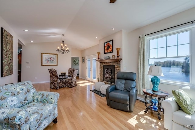 222 William St, Brownville, NY 13634 - living room featuring an inviting chandelier, a glass covered fireplace, baseboards, light wood-type flooring, and vaulted ceiling