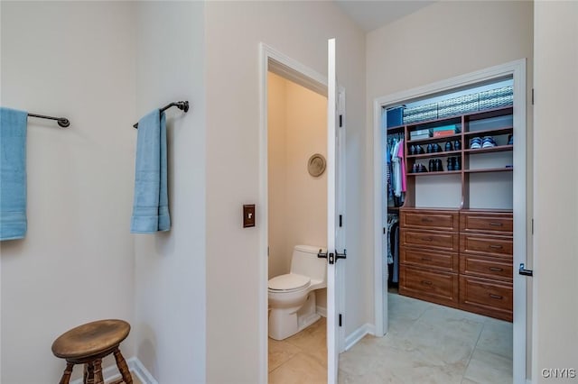222 William St, Brownville, NY 13634 - bathroom with a walk in closet, tile patterned floors, baseboards, and toilet