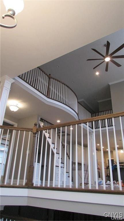 stairs with crown molding and ceiling fan