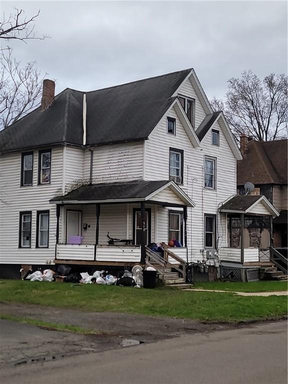 view of front of home with covered porch and a chimney