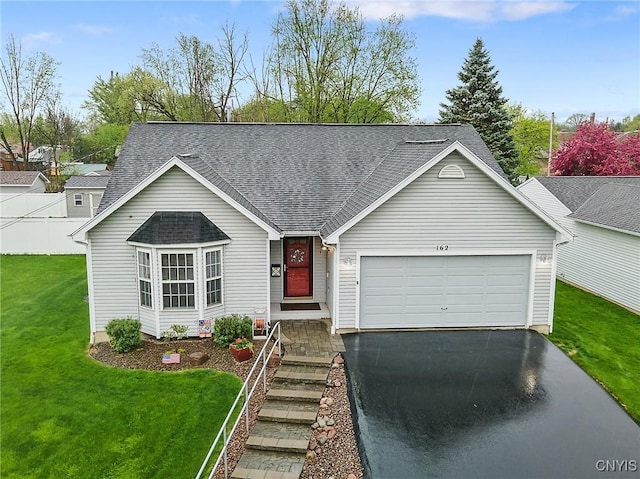 ranch-style home featuring a garage, fence, a front yard, roof with shingles, and driveway