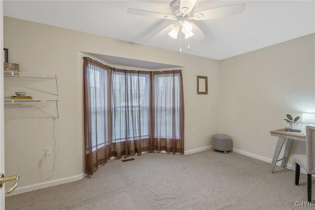 carpeted office space featuring plenty of natural light, a ceiling fan, and baseboards