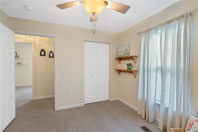 carpeted bedroom featuring a closet, baseboards, ceiling fan, and visible vents