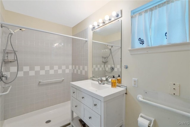 full bath with tiled shower and vanity