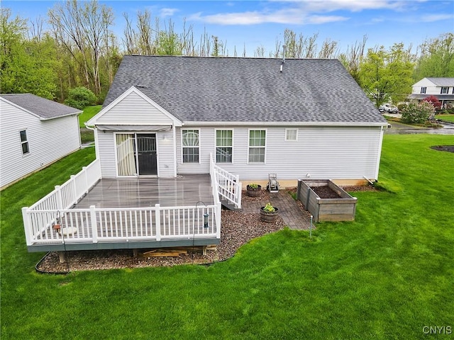 back of property with roof with shingles, a wooden deck, and a yard
