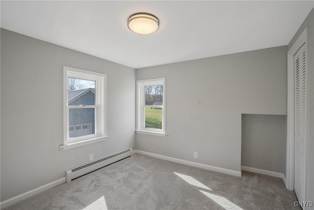 empty room featuring baseboards, carpet, and baseboard heating