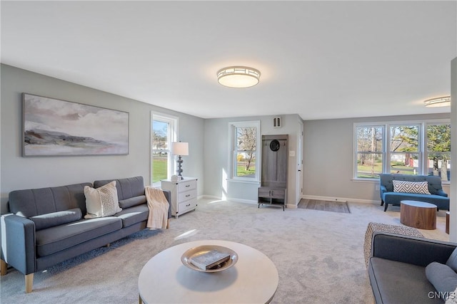 living area with light colored carpet and baseboards