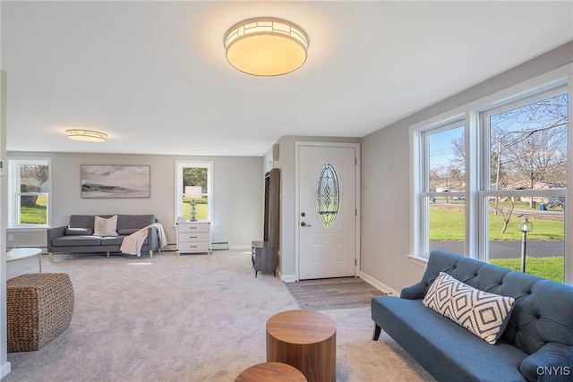 living area featuring light carpet, baseboard heating, and a wealth of natural light