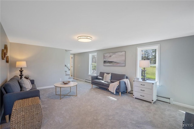 living area with carpet floors, a baseboard radiator, baseboards, and stairs