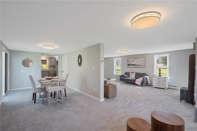 dining space featuring carpet floors, baseboards, plenty of natural light, and baseboard heating