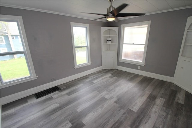 empty room featuring ornamental molding, visible vents, and plenty of natural light