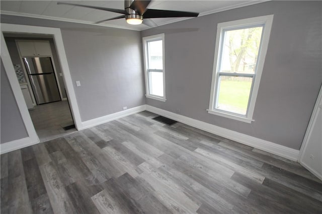 empty room featuring baseboards, visible vents, and plenty of natural light