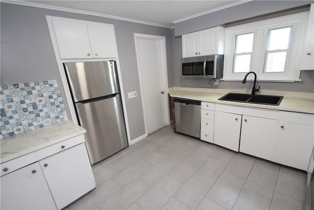 kitchen featuring light countertops, stainless steel appliances, crown molding, and a sink