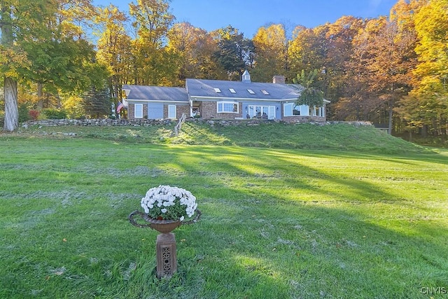 ranch-style house with a chimney and a front yard