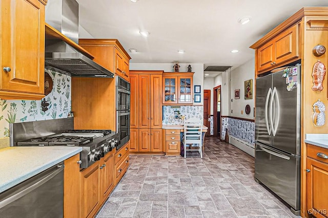 kitchen with brown cabinets, stainless steel appliances, wallpapered walls, and island exhaust hood