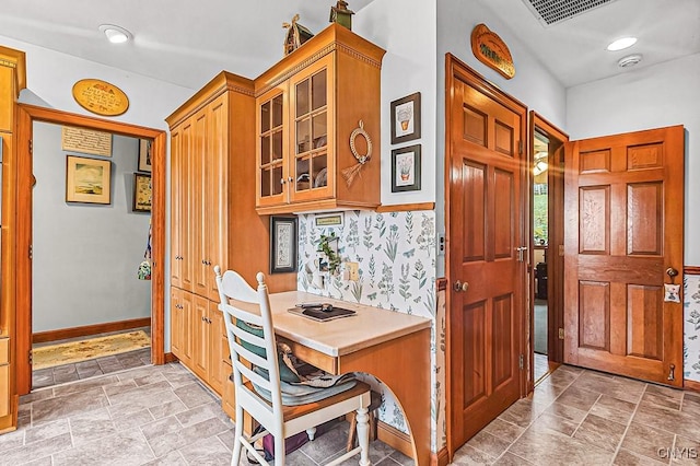 interior space featuring baseboards, stone finish flooring, and visible vents