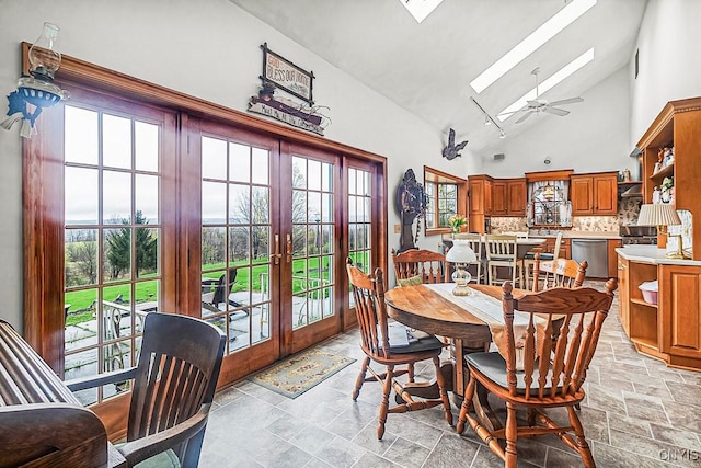 dining room featuring high vaulted ceiling, french doors, a ceiling fan, and stone tile floors