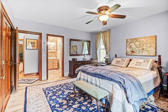 bedroom featuring a ceiling fan, baseboards, connected bathroom, and light wood-style flooring