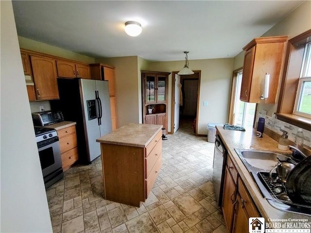 804 Smith Rd, Villenova, NY 14062 - kitchen featuring stainless steel appliances, a kitchen island, light countertops, and brown cabinets