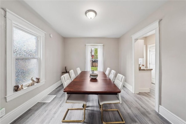 dining room with baseboards, visible vents, and wood finished floors