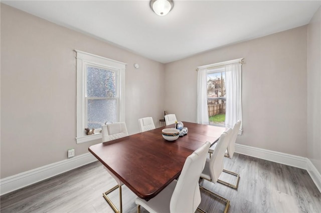 dining room featuring baseboards and light wood-style flooring