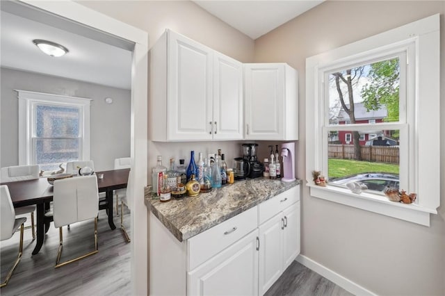 bar featuring baseboards and wood finished floors