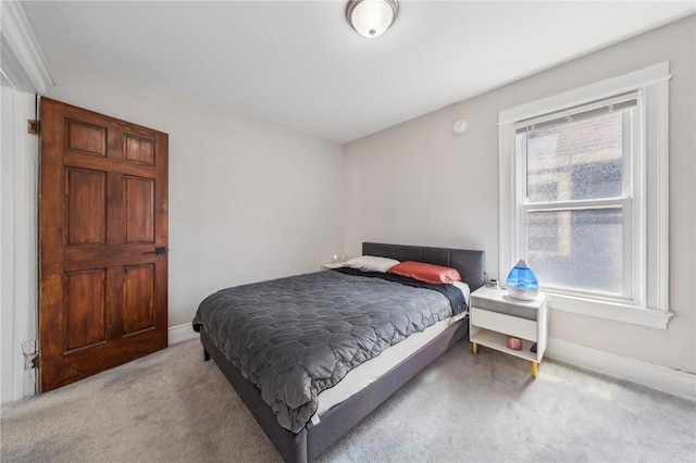 bedroom featuring light carpet and baseboards