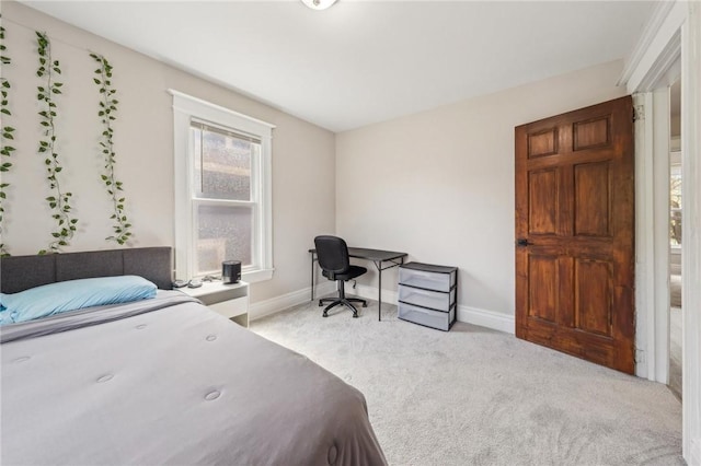 bedroom with light colored carpet and baseboards