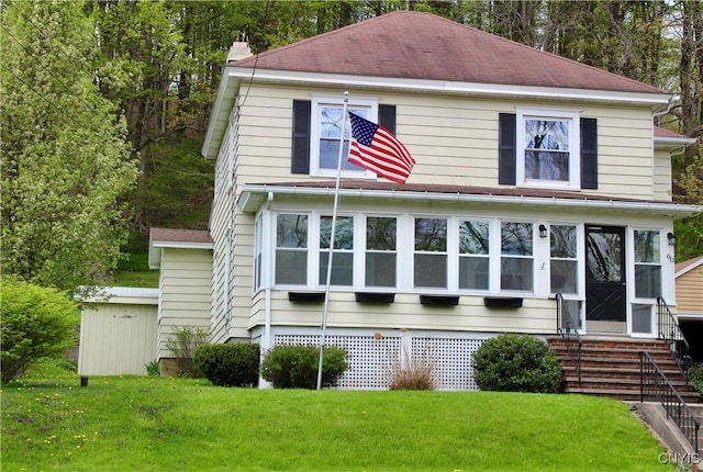 rear view of property with a yard and entry steps