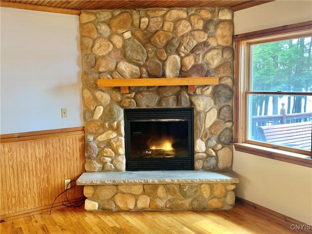 5048 State Route 28, Webb, NY 13420 - interior details featuring wainscoting, wooden walls, a stone fireplace, and wood finished floors