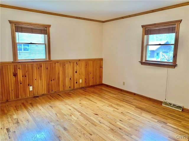 5048 State Route 28, Webb, NY 13420 - empty room featuring light wood finished floors, plenty of natural light, visible vents, and ornamental molding