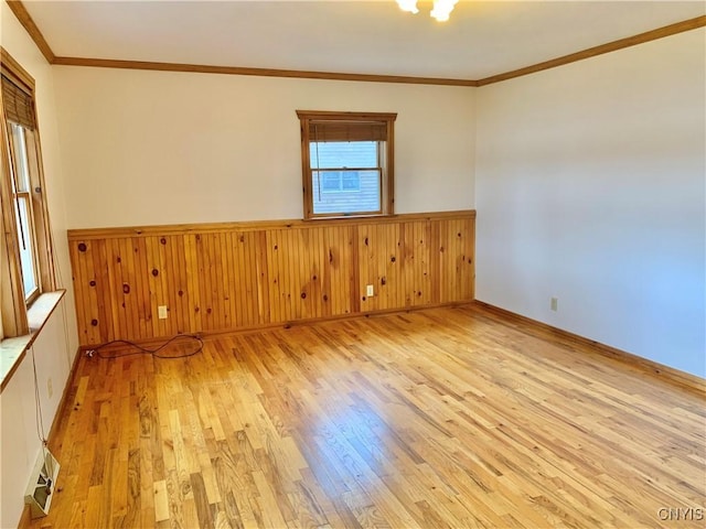 5048 State Route 28, Webb, NY 13420 - unfurnished room with ornamental molding, wood walls, wainscoting, and light wood-type flooring