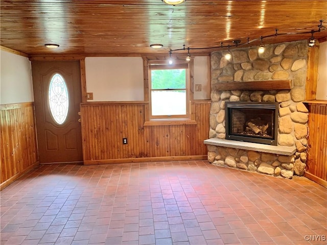 5048 State Route 28, Webb, NY 13420 - unfurnished living room with wainscoting, rail lighting, wooden walls, and a fireplace