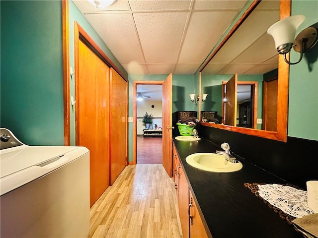 121 E William St, Bath, NY 14810 - bathroom featuring a sink, washer / clothes dryer, wood finished floors, a drop ceiling, and double vanity