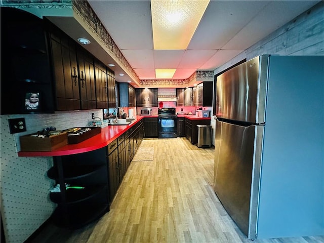 121 E William St, Bath, NY 14810 - kitchen featuring dark countertops, appliances with stainless steel finishes, light wood-style flooring, and a sink